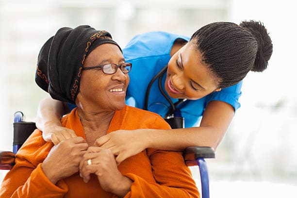 Caregiver gently holding hands with elderly family member